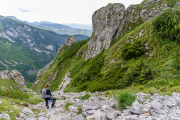 Fototapeta premium Female Hiker Resting on Rocky Mountain Trail