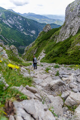 Naklejka premium Hiker Descending Steep Rocky Mountain Pass