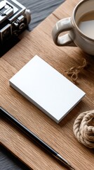 Blank business cards on a wooden desk with coffee and camera.