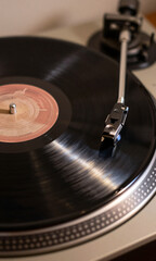 shot vinyl record spinning rapidly front soft pulsing glow lights emanating turntable metal edges capturing