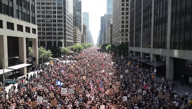 Massive crowd of diverse people demonstrating on a wide avenue surrounded by modern downtown skyscrapers