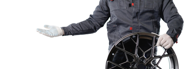 Mechanic displaying high-performance car wheel rim on isolated background