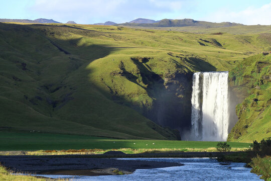 Majestic Waterfall Flowing Through Icelandic Green Valley