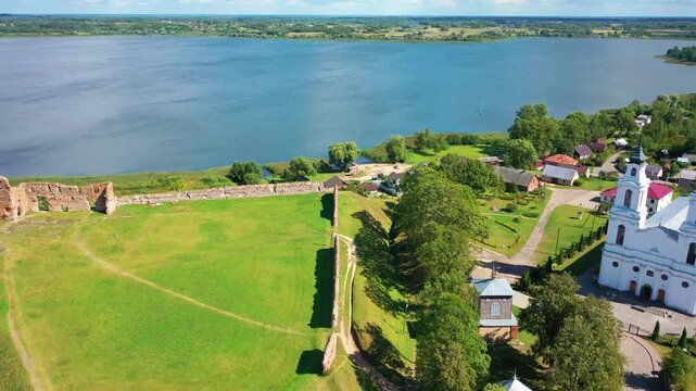 Aerial 4K video from a drone of the city of Ludza. In the background, the Ludza Medieval Castle, the city's churches, and lakes are visible on a sunny summer day. Ludza, Latgale, Latvia. 