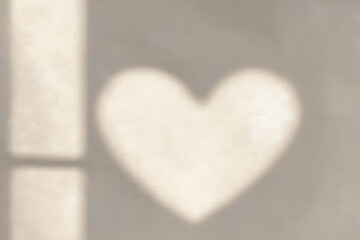 Fototapeta premium Heart shape shadow on wall from sunlight through window, lovely abstract background for design
