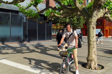 Young indian man standing with a bicycle containing fresh produce, promoting sustainable commuting and healthy lifestyle in the city