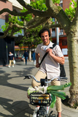 Smiling indian man on a bicycle with groceries, representing eco friendly transport and sustainable lifestyle in the city