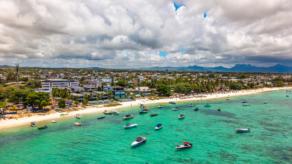 Vibrant tropical travel scene: shallow turquoise ocean water with numerous recreational boats and coastal urban development