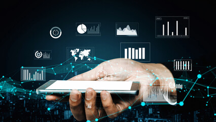 A hand holds a smartphone displaying various data visualizations, representing trends in technology and business analytics in a modern urban environment. Xenic
