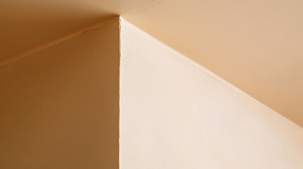 Abstract interior featuring the corner where a wall meets the ceiling. The beige hue creates a warm, inviting atmosphere, accentuated by natural light casting shadows, adding depth.
