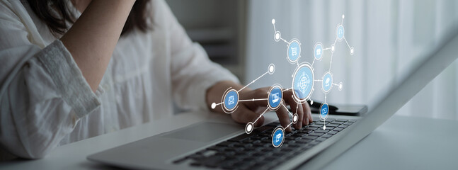 A woman interacts with a laptop while digital icons representing data and networks emerge, illustrating the intersection of technology and innovation in a modern workspace. Tessel