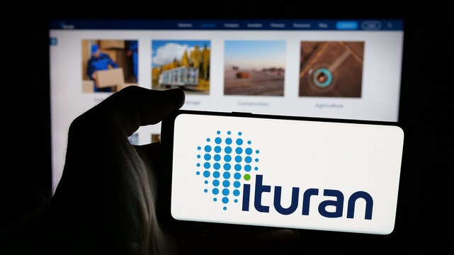Stuttgart, Germany - 12-17-2025: Person holding mobile phone with logo of company Ituran Location and Control Ltd. on screen in front of web page. Focus on phone display.