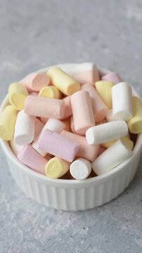 Mini marshmallows in white, pink, and pastel colors, a colorful Christmas dessert. Marshmallows as a food background for your design