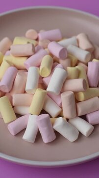 Mini marshmallows in white, pink, and pastel colors, a colorful Christmas dessert. Marshmallows as a food background for your design