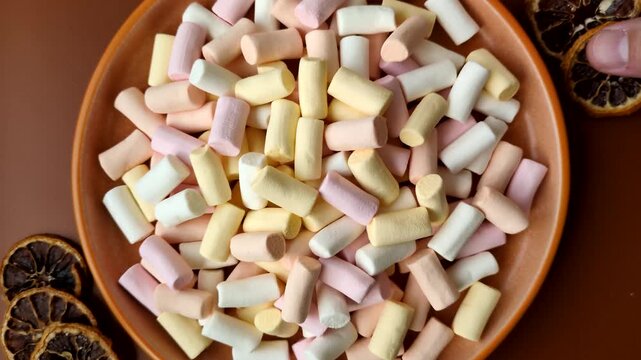Mini marshmallows in white, pink, and pastel colors, a colorful Christmas dessert. Marshmallows as a food background for your design