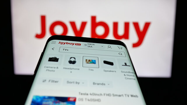 Stuttgart, Germany - 12-17-2025: Mobile phone with website of e-commerce company Joybuy (Joybuy.com) on screen in front of logo. Focus on top-left of phone display.