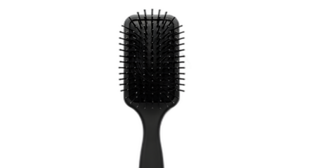 Sleek black paddle hairbrush featuring collected strands of dark hair is isolated on transparent background