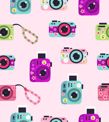 Pattern of cameras with stickers on a light pink background.
