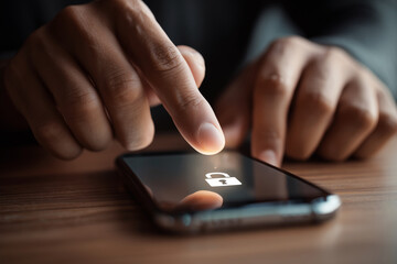 A person is pointing at a phone screen with a lock icon on it