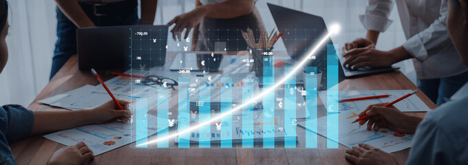 A group of professionals collaborate in a modern office setting, utilizing digital data analysis and growth chart visualization to drive business strategies. Axiom
