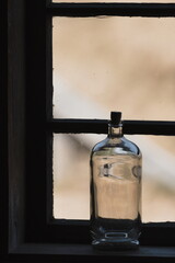 an old bottle against the background of a window