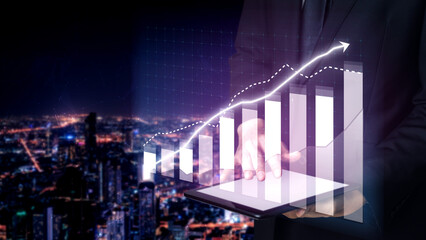 A professional businessman holds a tablet displaying a digital growth graph, symbolizing business...