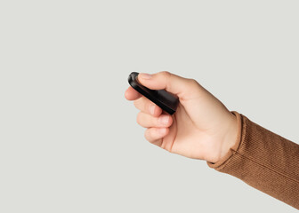 Hand holding a black remote control