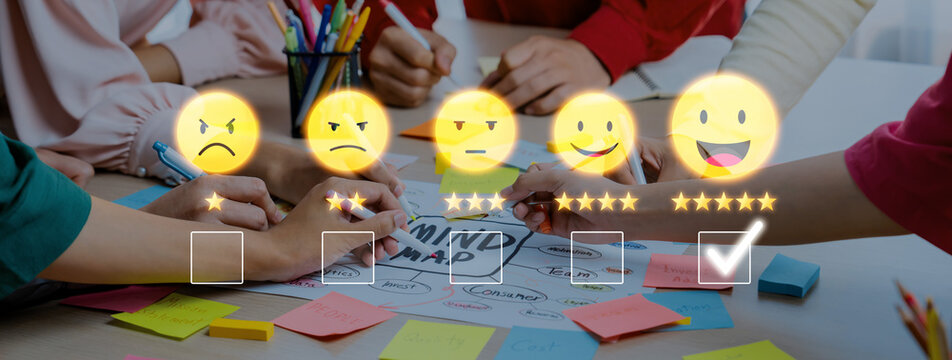 A diverse group of individuals collaborates at a table, using smiley icons and colorful sticky notes to rate ideas during a creative brainstorming session. Trope