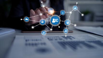 A businessman taps on a touchscreen interface surrounded by digital network icons, symbolizing data...