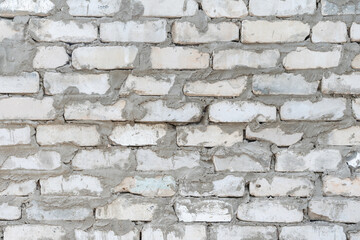 Fototapeta premium White brick wall creates textured backdrop in rustic style, highlighting the marks of dirty mortar, poorly constructed rows of brick, building materials, and natural aging process of the stonework.