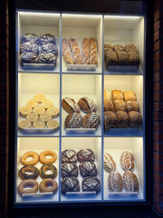 Bakery shop window with bread, baguettes, and pastries.