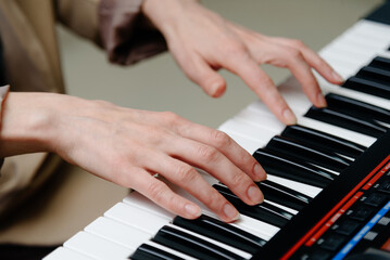 female pianist hands on black and white piano keyboard, close-up view, young woman playing piano, professional musician