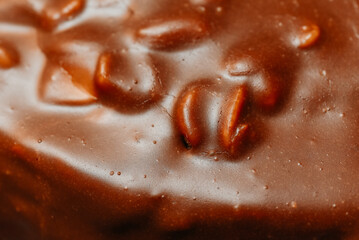 large brown sliced chocolate cake with cream and peanuts, sweet tasty food for holydays and celebrating, selective focus