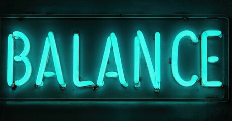 Bright neon sign displays word balance. Dark background emphasizes glowing turquoise lettering. Simple, direct message.