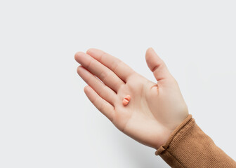 Close-up of a hand holding a pill