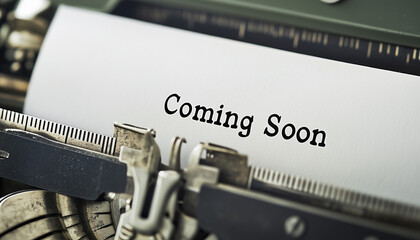Vintage typewriter with paper sheet typed Coming Soon in black font. Old mechanical writing machine closeup. Retro office equipment