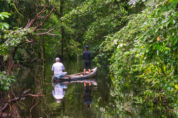 Local father and sin fishing in the canals in the Tortuguero National Park in Costa Rica after a rain storm