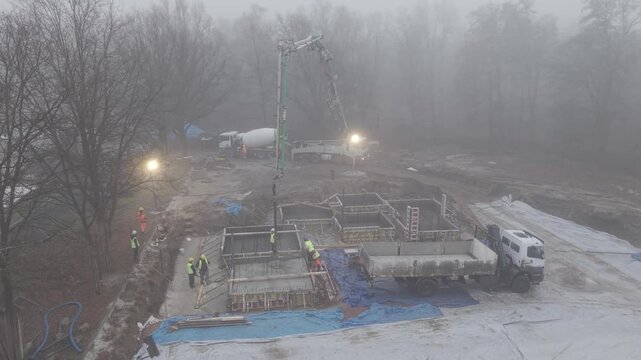 Wylewanie betonu na budowie, widok z drona podczas lekkiej mgły