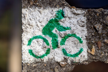 Bicycle symbol painted on a wall showing a cyclist in an outdoor area during daylight hours