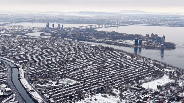 Aerial winter view of Montreal suburbs, snowy angrignon park and river near Lachine and Verdun under cloudy sky. g.