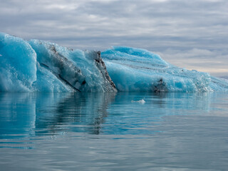 Blue iceberg glistening in sunlight floating in Iceland's Jokulsarlon Glacier Lagoon