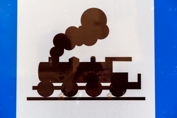 Train graphic on a blue and white sign showing steam rising from the locomotive in a simple and clear design