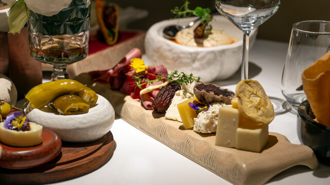 Luxury restaurant charcuterie board with artisan cheeses, cured meats, dates and edible flowers served at elegant Mediterranean dinner