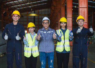 group five industrial worker standing together in factory setting, wearing safety helmets and reflective vest. image represent teamwork, safety compliance, professionalism in industrial environment.