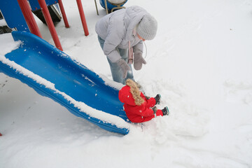 Winter Fun on Snow-Covered Slide with Child in Red