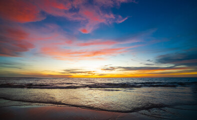 serene panorama image capture beauty sunset over calm ocean. sun low on horizon casting warm golden glow across sky and reflect off gentle wave. warm orange near creating peaceful calm atmosphere.