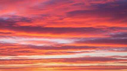 Fototapeta premium Vibrant orange and pink sunset with clouds