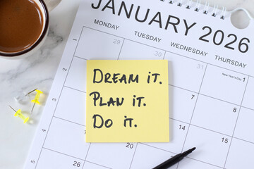 Dream, plan, do, inspirational handwritten quote on 2026 calendar with coffee cup. Top view. Business goals, vision, and aspirations concept.