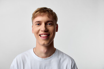 Smiling young man in a white tshirt in a studio headshot, casual and friendly, showcasing confident expression and approachable vibe for lifestyle, corporate, marketing, and social media use