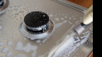 Cleaning process of a stovetop with soapy water, showing the gradual removal of grime and buildup from the surface, enhancing kitchen cleanliness and hygiene